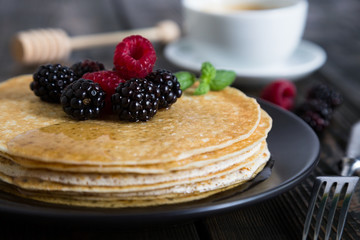 Thin pancakes with fresh berries and coffee