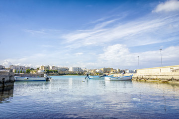 Fototapeta na wymiar White sail boats moored at Otranto harbor, Italy