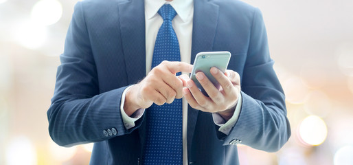 Business man hands using smart phone over blur office with copy space background, businessman on phone