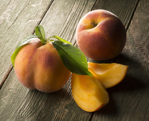 Peach with leaves on the wooden table
