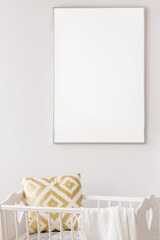 White poster mockup over baby cradle