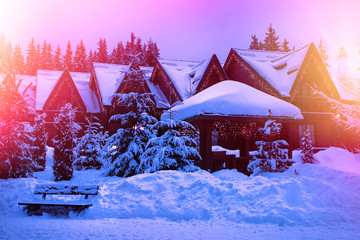 A fairy-tale house in the woods amid the snow-covered fir trees, Christmas landscape. Winter nature.