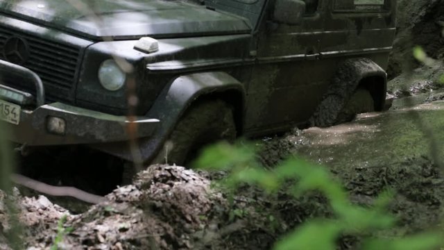 Black SUV got stuck in the mud in the forest, off-road