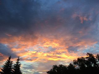 Beautiful sky with clouds with a setting sun with red orange hues