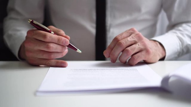 businessman reading and signing business partnership contract in office