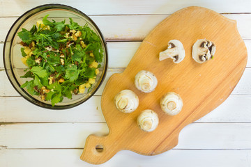 Preparation of a vegetarian salad. Slicing fresh mushrooms of champignons