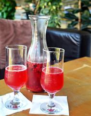 Summer lemonade with raspberry and leaves mint in a glass jug