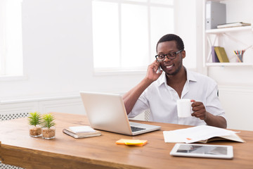 Obraz premium Young black businessman call mobile phone in modern white office