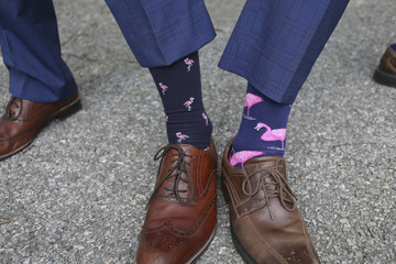 Groom and Groomsmen in Blue Suits Comparing Pink Flamingo Socks
