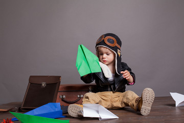 little boy pilot plays in the paper plane