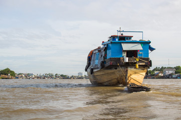 A big cargo boat on the Mekong river at cloudy day in Mekong Delta, southern Vietnam.