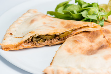Slice of spicy closed pizza on a plate