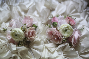 Obraz na płótnie Canvas Pink and White Wedding Corsages on a Ruffled Fabric