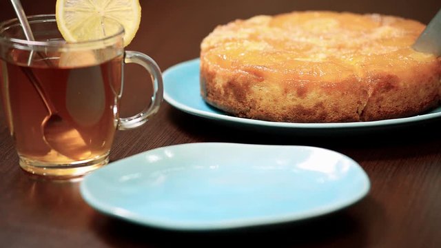 Pineapple upside down cake with cherries on a platter. Put piece pineapple cake in bowl