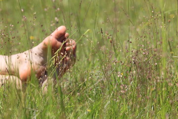 Füße in Sommerwiese beim Sonnenbad