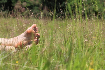 Füße in Sommerwiese beim Sonnenbad