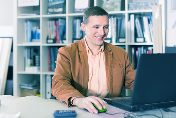 Positive manager working at office desk