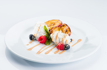 Restaurant dessert. Vanilla ice cream with fruits and caramel syrup on a light background
