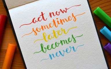 ACT NOW SOMETIMES LATER BECOMES NEVER hand lettered on notebook