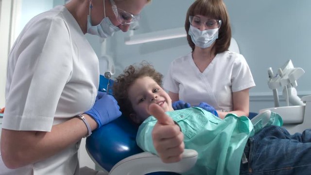 The little patient is satisfied with the inspection of the dentist