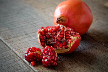 Ripe pomegranate fruit on wooden vintage background.