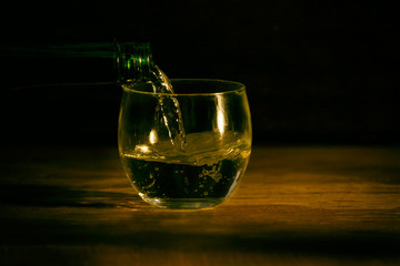 Glass on wood table dark background
