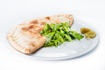 Delicious pizza Calzone on a plate, light background