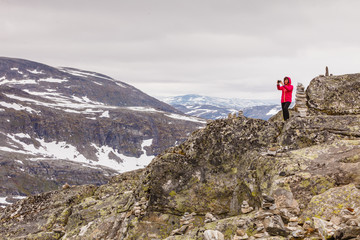 Naklejka premium Tourist taking photo from Dalsnibba viewpoint Norway