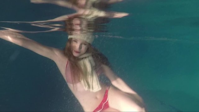 Underwater shooting of a beautiful girl in clothes