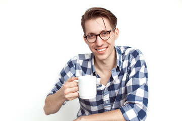 Smiling young man holding white mug
