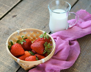 Strawberry in a basket and a glass of milk