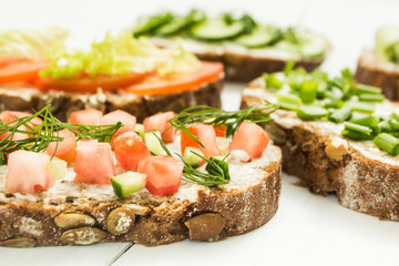 Different kinds of colorful sandwiches on a white wooden background. Healthy lifestyle and diet.