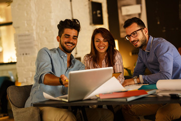 Group of casual concept designers working on new project .They using laptop and discuss about concept.Solving problems with positive attitude.