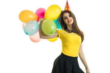 Fototapeta na wymiar horizontal portrait of a beautiful young brunette that rose in the hand a lot of balloons and smiling