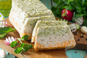 Meat cake made with minced meat, broccoli and carrots on a kitchen wooden table with fresh vegetables. The concept of a healthy diet.