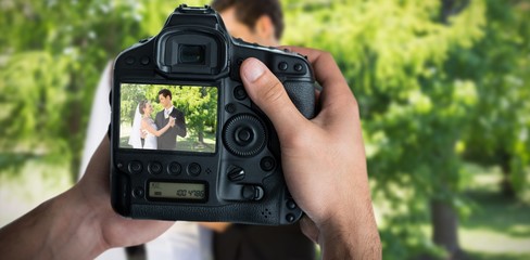 Composite image of cropped image of hands holding camera 