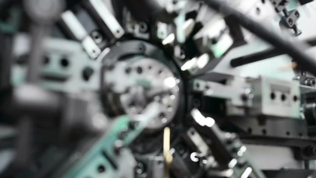 The work of the mechanism of automatic CNC bending machine. Manufacture of a spring of fine wire. Gradual smooth focus on the subject
