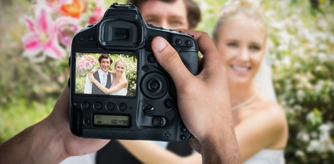 Composite image of cropped image of hands holding camera 