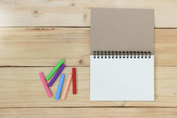 Blank notebook with chalk colour on wood table.