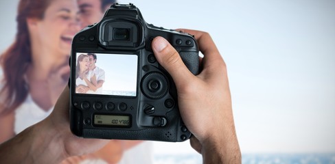 Composite image of cropped image of hands holding camera 