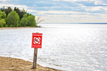 Warning sign on the river - bathing is forbidden, dangerous to life