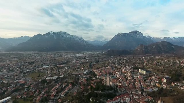 Flight over a town next to Alps in Northern Italy