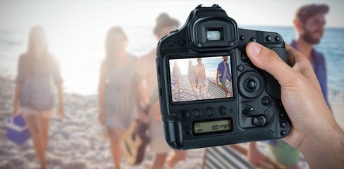Composite image of cropped hand of photographer holding camera  - Powered by Adobe