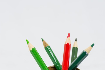 Red color pencil with group of green color pencil