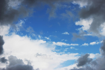 Huge white cumulus clouds against blue sky in spring.