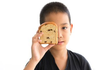 Asian boy shutting eyes with whole wheat raisin loaf bread  isolated on white background