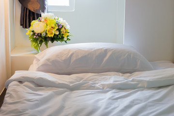 close-up white bedroom and pillow with yellow flowers near the window
