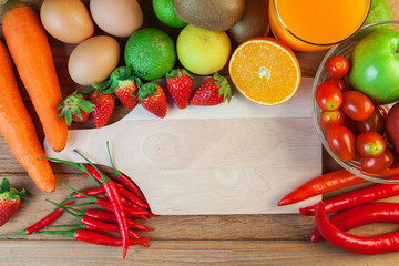 Healthy concept with mixed fruits and vegetables on wooden background