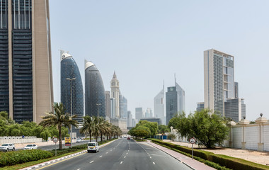 Fototapeta na wymiar Palm Tree Lined Street Through Dubai on Sunny Day