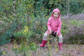 Happy little girl dancing with binoculars in hand